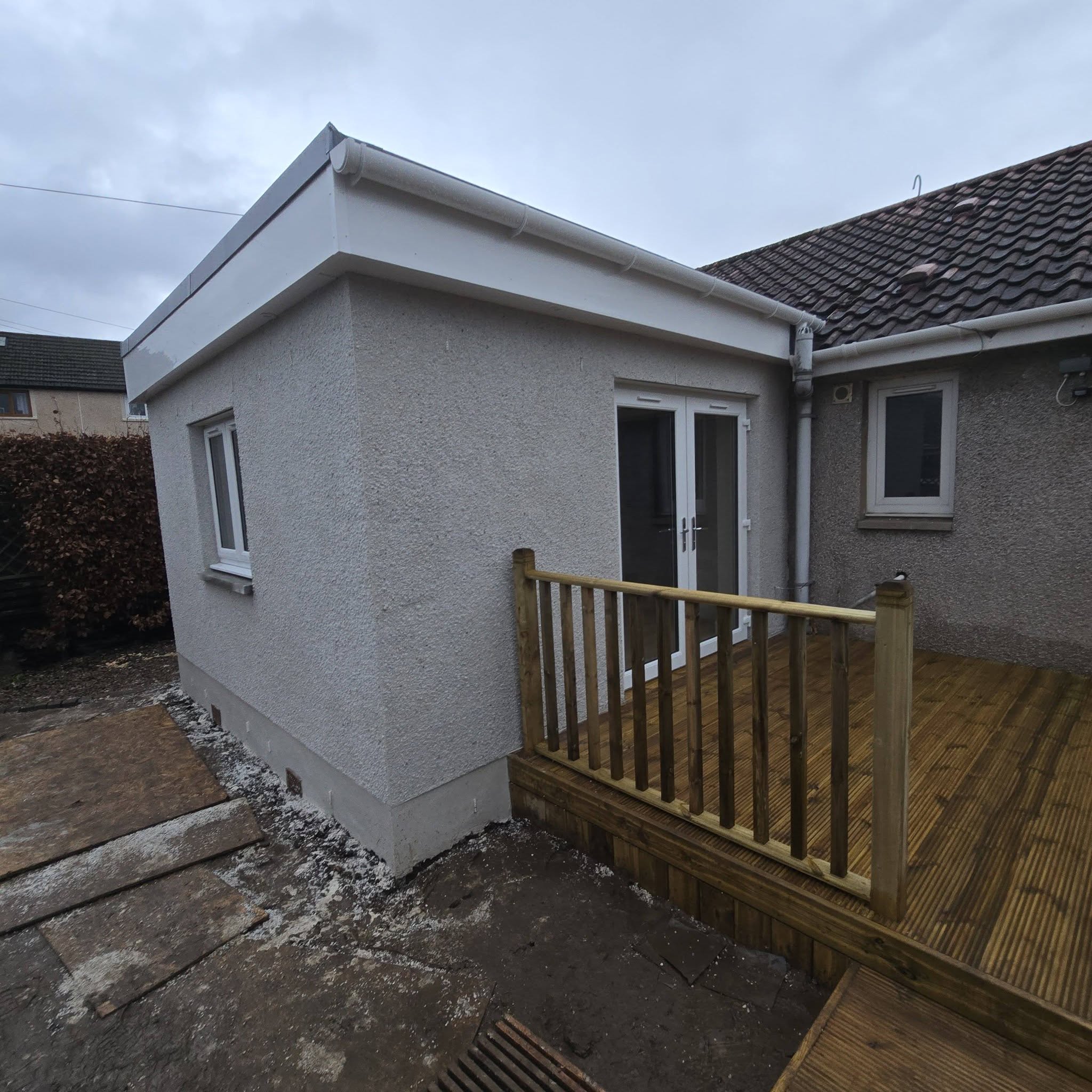 Rendered rear extension with new timber decking by Morgan Joinery Services
