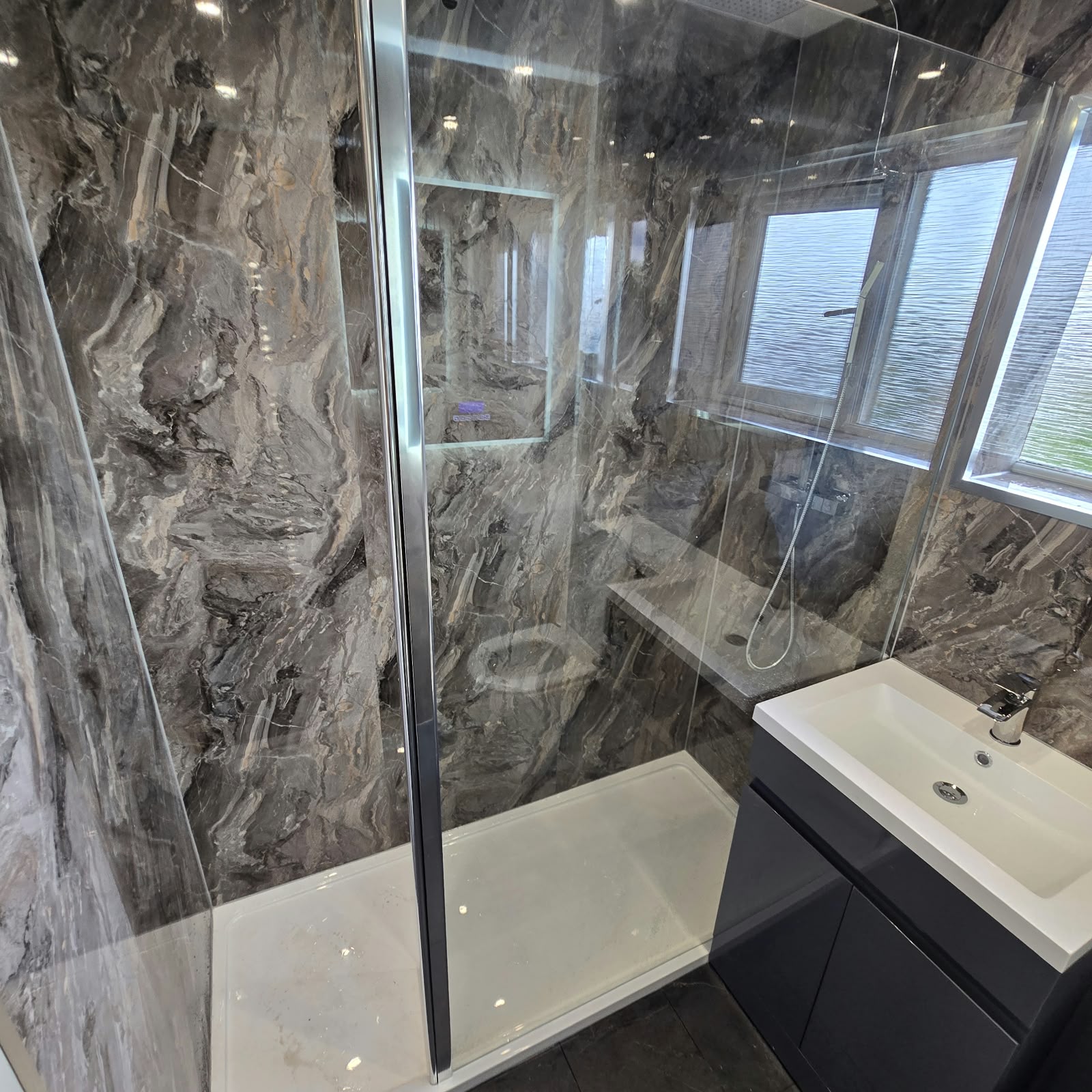 Marble-effect wet wall shower room with a walk-in tray