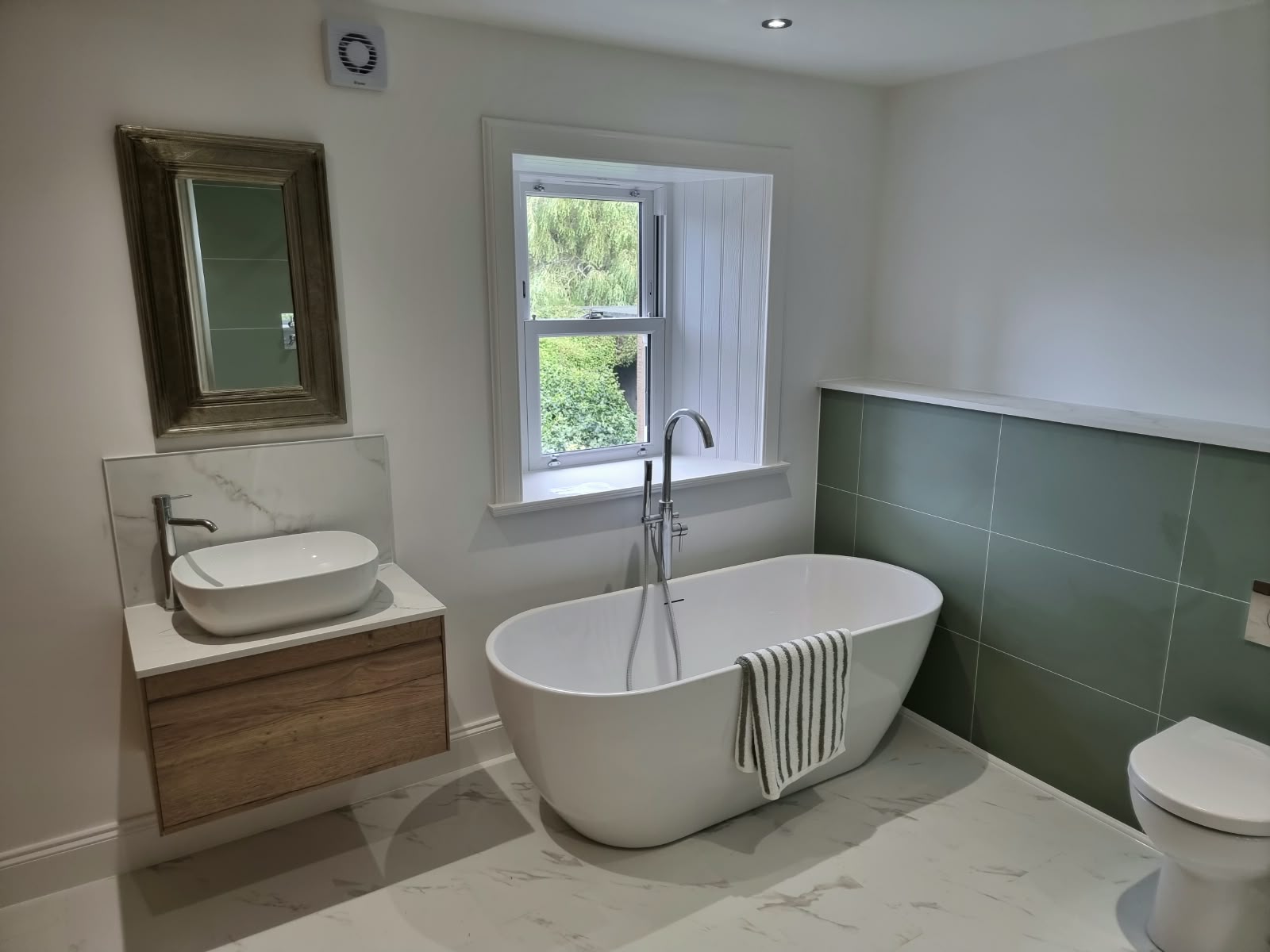Bathroom with a freestanding bath and wood vanity