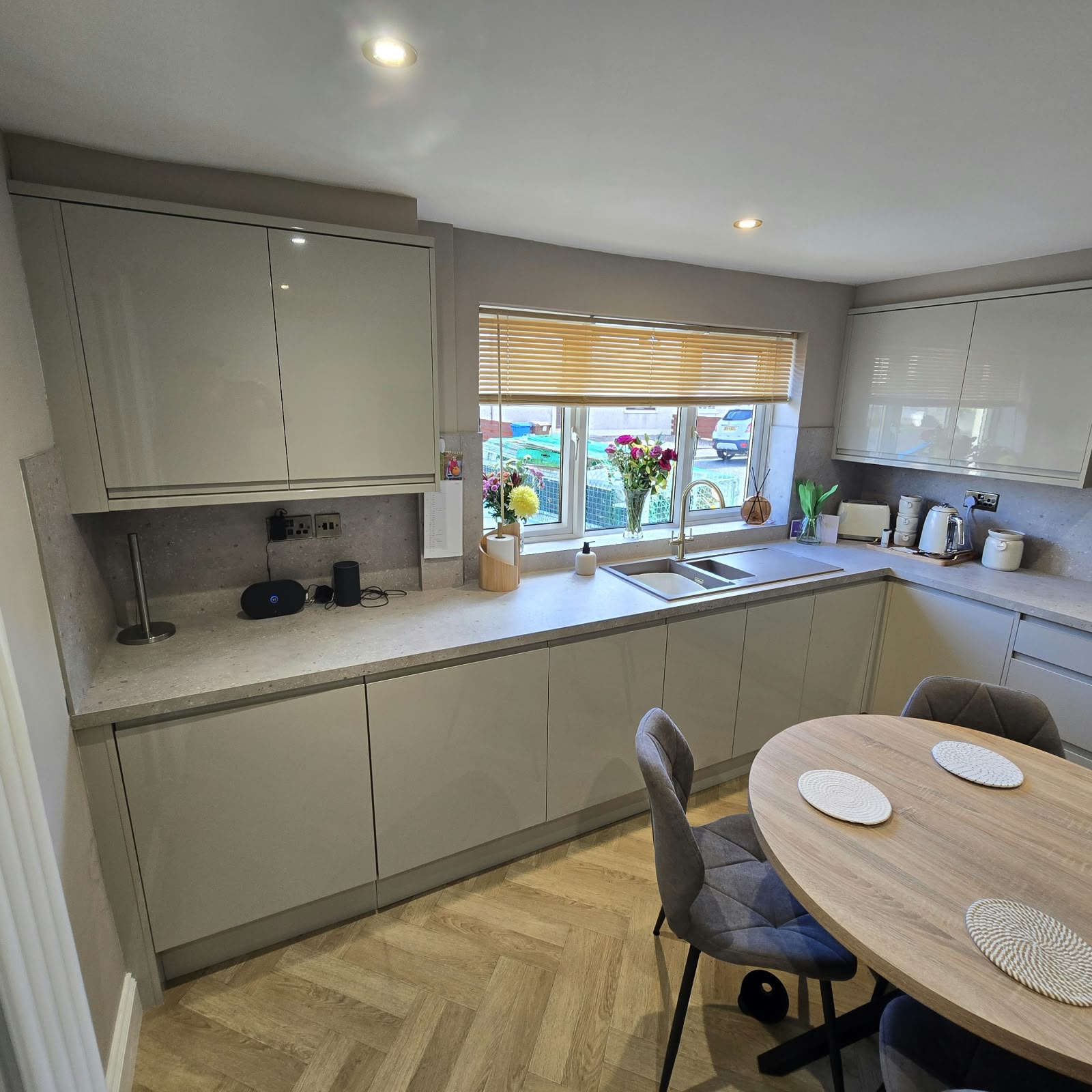 Gloss kitchen with a dining table and herringbone floor