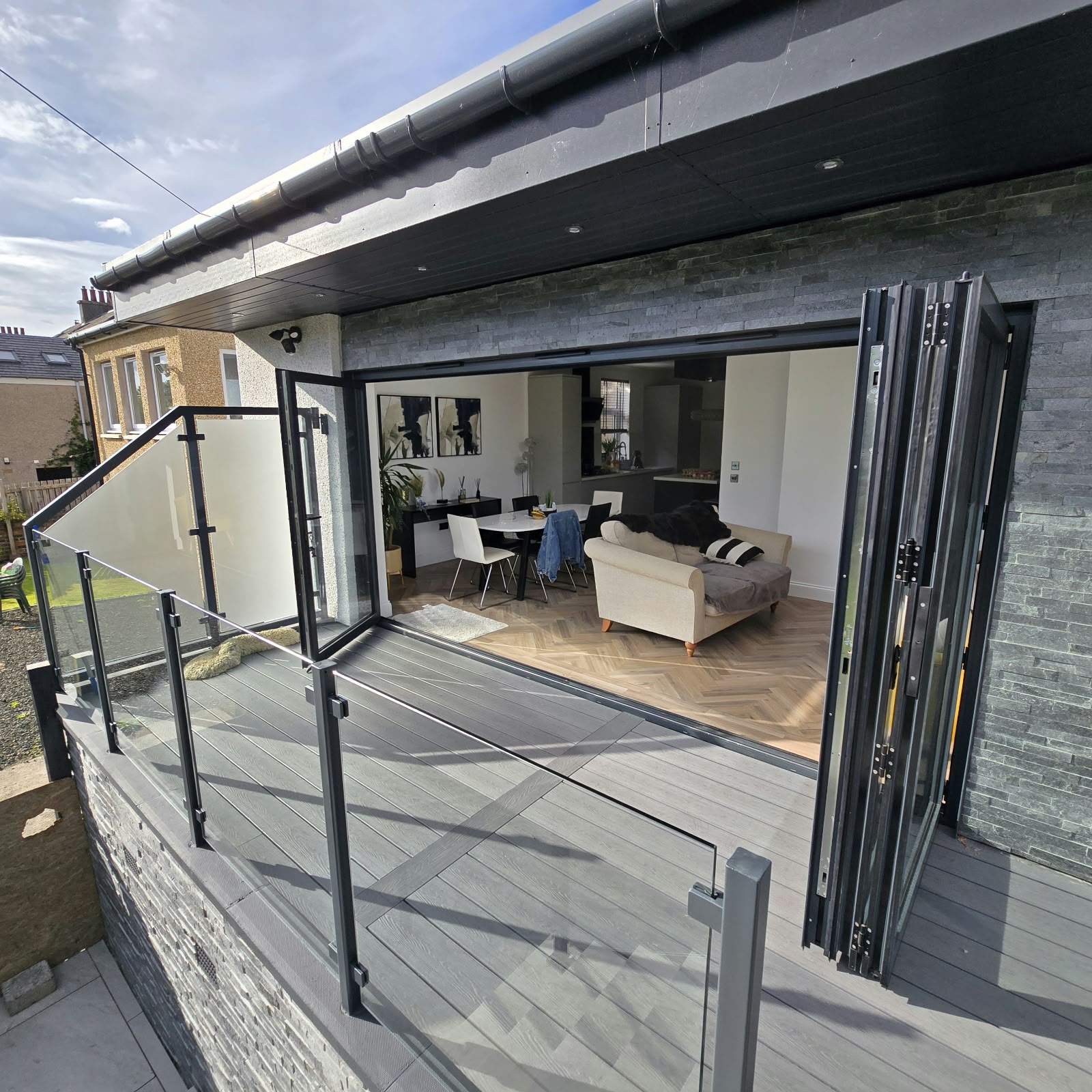 Raised garden room with decking, glass balustrade and bi-fold doors