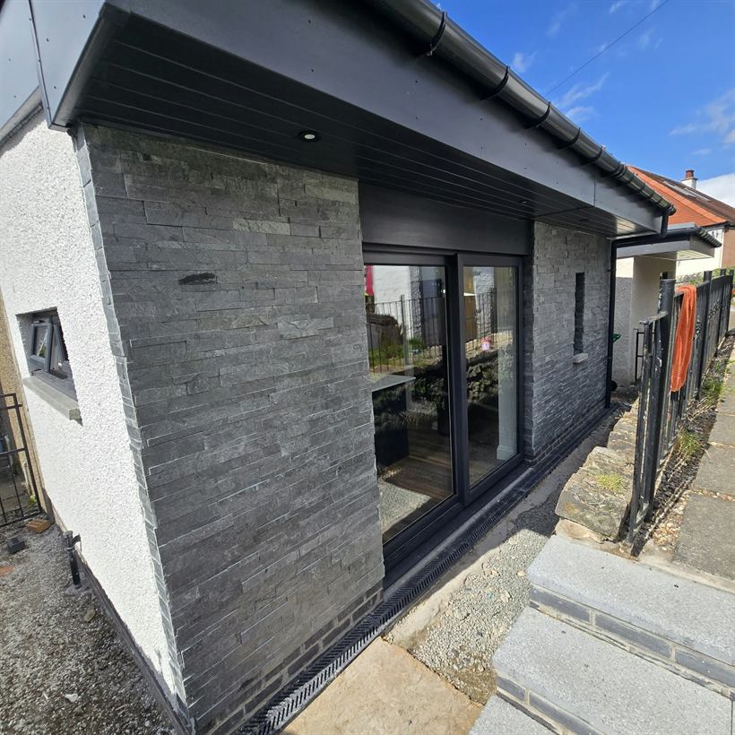 Slate-clad extension with a sliding door