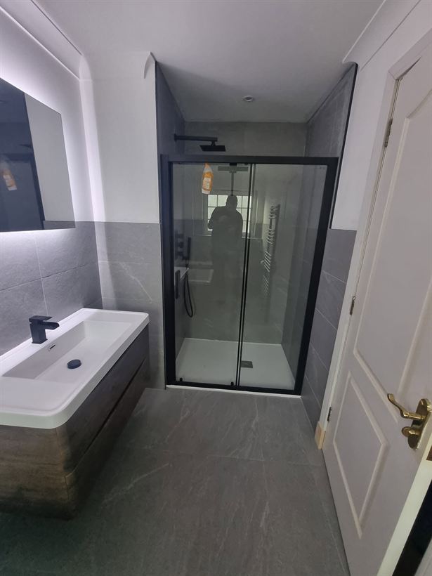 Black-framed shower enclosure and floating vanity unit