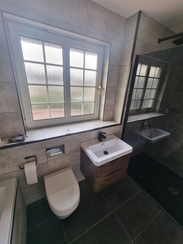 Bathroom with vanity unit, wall-hung toilet and tiled walls