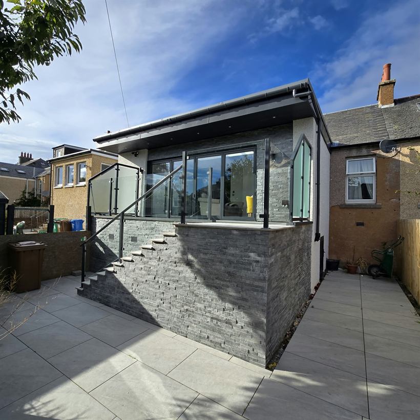 Raised slate and render extension with glass balustrade